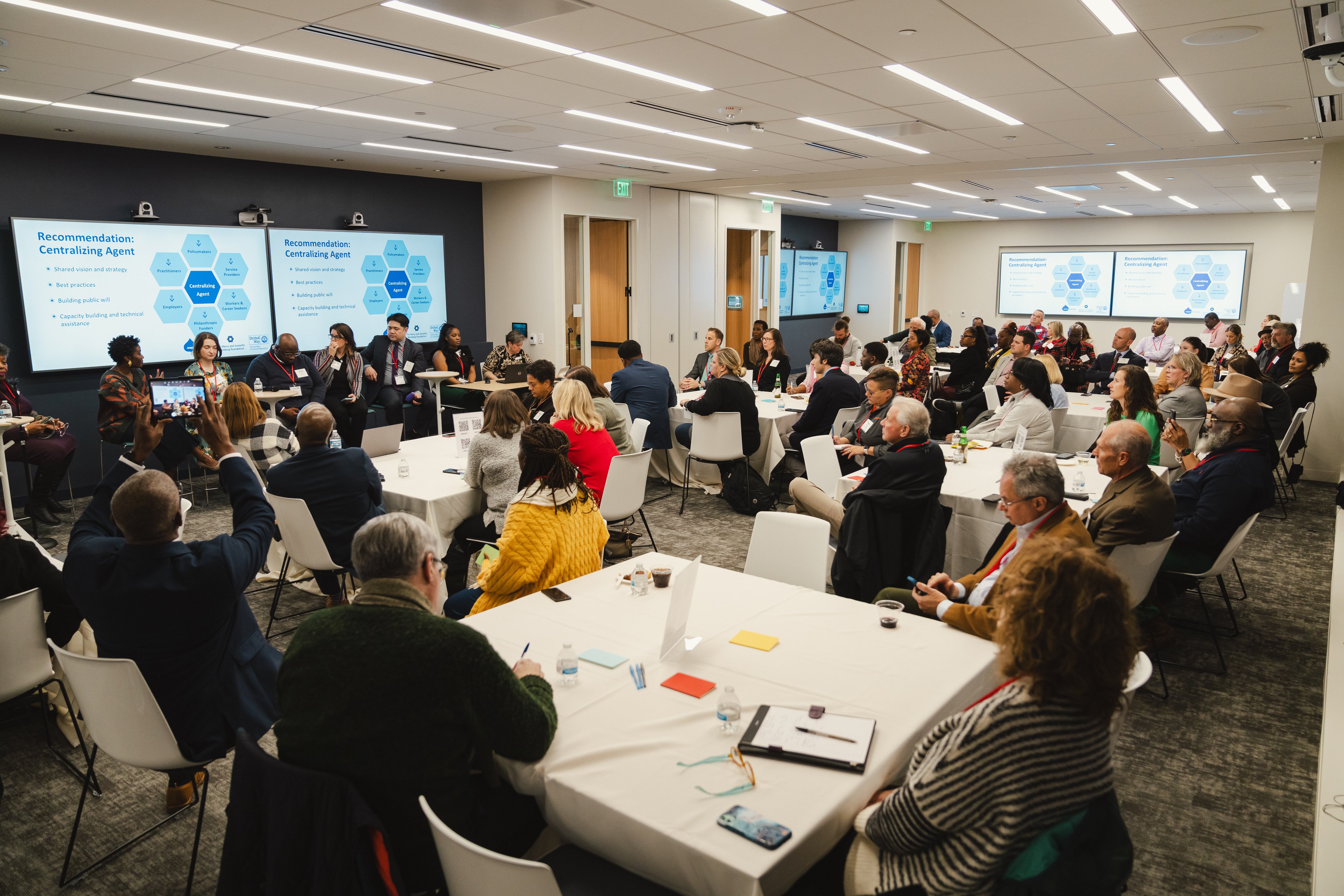 Group of people in a room listening to a presentation