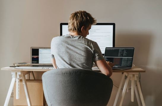 Person working from home with three monitors