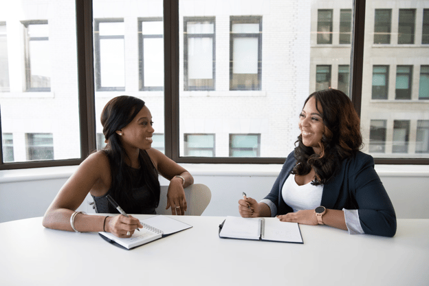 smiling coworkers taking notes