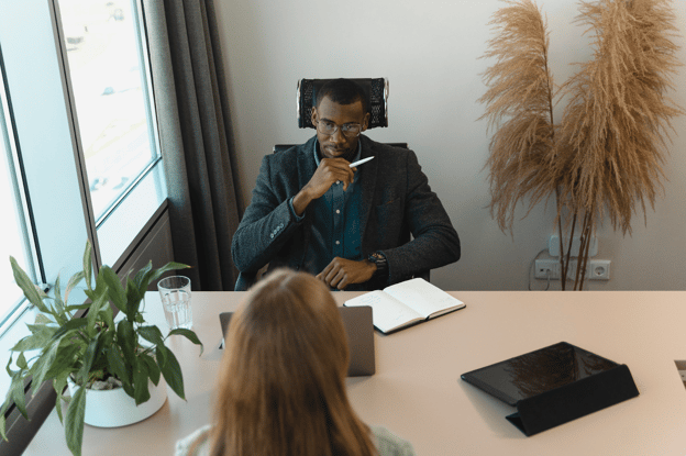 CEO at desk talking to woman employee