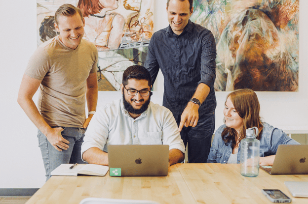 Coworkers collaborating behind laptop